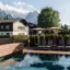 Ein Pool mit Stühlen und Sonnenschirmen neben einem Haus